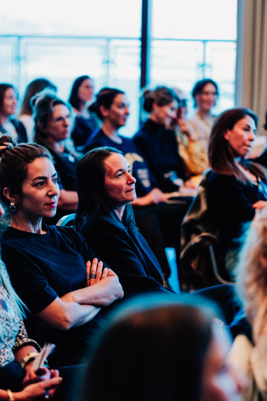La sala de un encuentro de Coty: asistentes sentadas escuchando, con los ventanales detrás